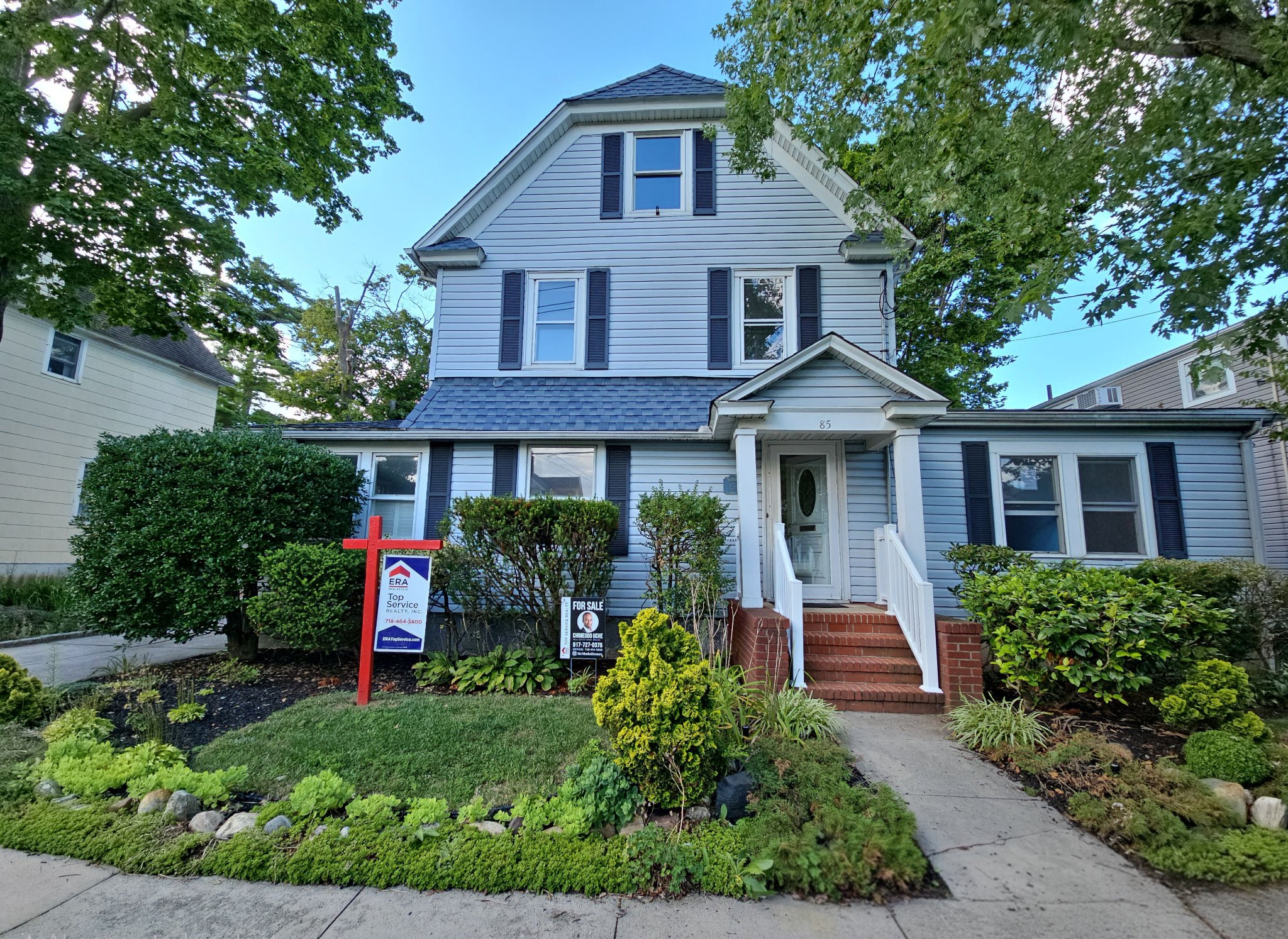Two-story home with ERA Top Service Realty for-sale sign in the front yard