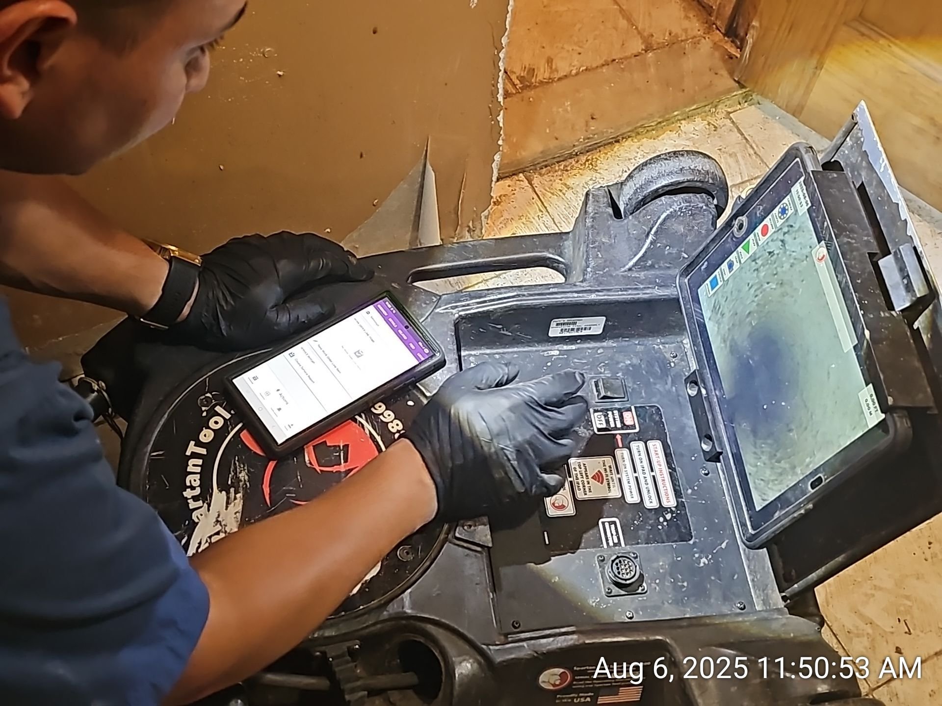Technician using inspection equipment and a mobile device inside a property