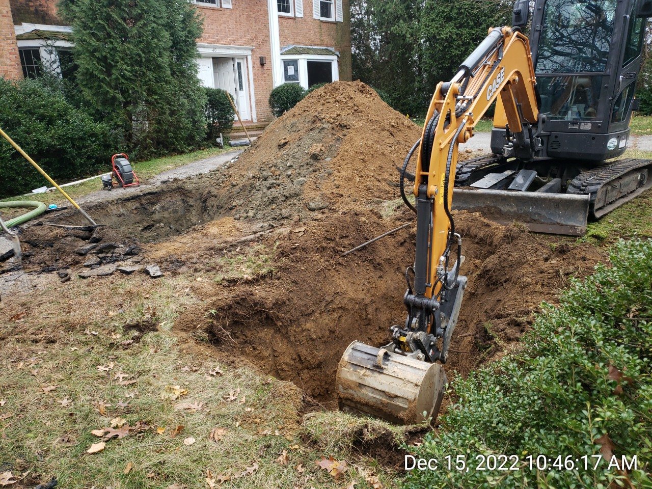 Excavation equipment and open ground at a residential repair site